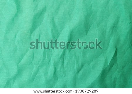 Background photo with wrinkles on green fabric