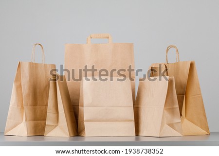Brown paper bag with handles, empty shopping bag with area for your logo or design, food delivery concept Royalty-Free Stock Photo #1938738352