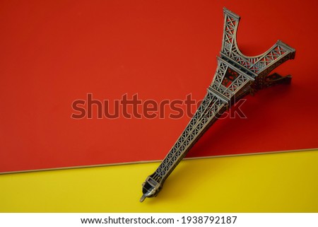 Statue of the Paris tower on red and yellow backgrounds. High quality photo
