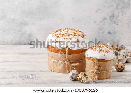 Traditional easter sweet bread with quail eggs over white wooden table. Easter cake with sugar icing decorated with nuts. Side view, copy space. Easter treat, holiday symbol