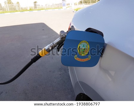 Flag of Idaho on the car's fuel tank filler flap. Petrol station. Fueling car at a gas station.