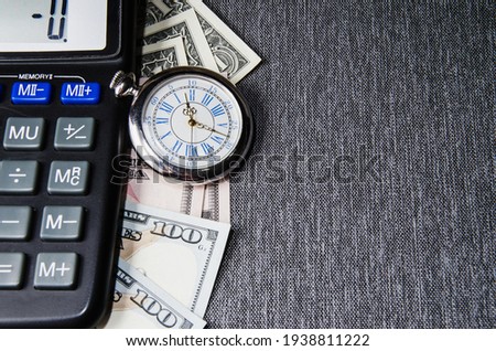 A pocket watch, or clock, timepiece on a pile of cash. Good use for any financial inference where time is a factor of money