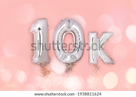 Silver Number Balloons 10K, meaning ten thousand, on pink background. Holiday Party Decoration, 10k followers or likes, social media or postcard concept with top view Royalty-Free Stock Photo #1938811624
