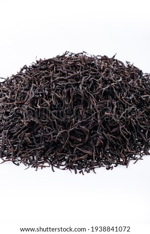 Heap of black tea on a white background. Dry black tea leaves isolated on white background, delicious, natural. Flat lay.