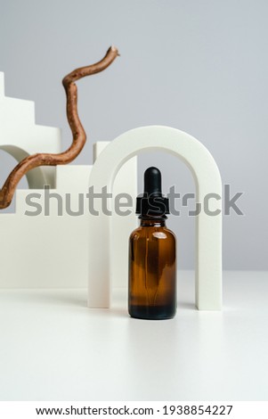 Massage oils in a dark glass jar. Essence for skin health against the backdrop of arches. Trendy style. Geometric figures. Photo in monochrome style. Mockup for your product. Conceptual photo. 