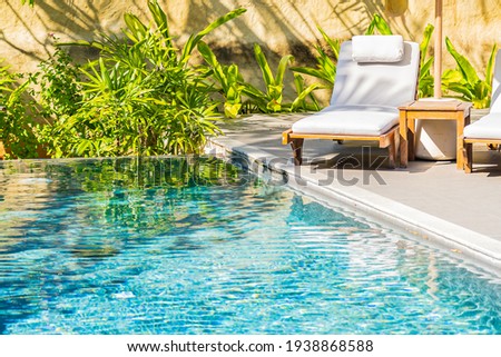 Umbrella and chair around outdoor swimming pool in resort hotel for vacation leisure