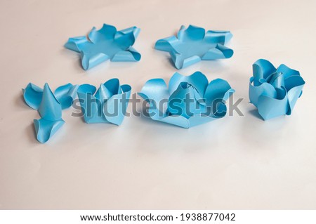 Step to step, paper 3 d flower make origami rose and  handmade  romantic bouquet for valentine, wedding, card, and decorate backdrop. Focus blue rose paper on the white background.