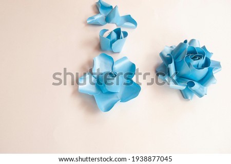 Step to step, paper 3 d flower make origami rose and  handmade  romantic bouquet for valentine, wedding, card, and decorate backdrop. Focus blue rose paper on the white background.