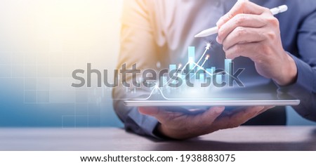 Businessman holding tablet and point to chart on virtual screen. Business strategy abstract graphic background and Digital marketing of sales and economic growth graph chart