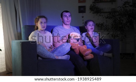 stay home. family - dad, daughter and small child coronavirus are watching tv. quarantine happy family together concept. happy family watching tv together. kid dream. people watching online movies