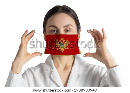Respirator with flag of Montenegro Doctor puts on medical face mask isolated on white background.