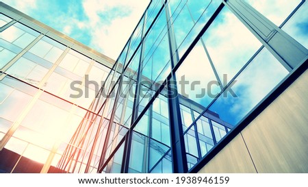 Modern building in the city with sunlight. Abstract texture and blue glass facade in modern office building., Retro stylized colorful tonal filter effect. Sunlight. Royalty-Free Stock Photo #1938946159