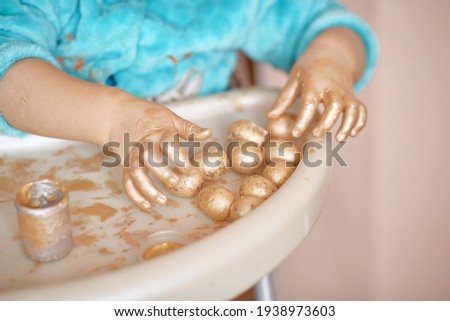 Easter concept with copy space. Child is painting Easter eggs. The child develops fine motor skills with bright paints. 