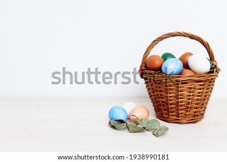 Easter eggs in a basket on a light background and a church holiday