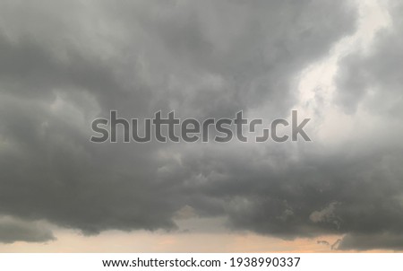 Thunder cloud, Nimbostratus Clouds A gray Style rolls are round to each other in sheets or layers and Huge scary storm it's going to rain heavily at Thailand.no focus Royalty-Free Stock Photo #1938990337