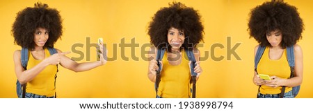 Portrait of a cheerful positive photo of young American blogger selfie video blogging calling scream wow omg wearing striped pants isolated yellow color background