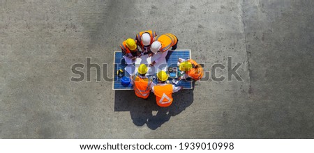 Top view of architectural engineer working on solar panel and his blueprints with Solar photovoltaic equipment on construction site. meeting, discussing, designing, planing, Clean energy concept