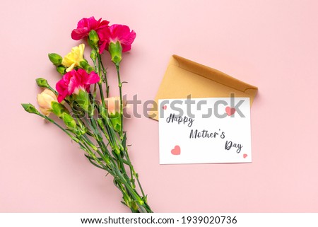 bouquet of carnations, envelope with postcard isolated on pink background Top view flat lay Happy mother's day concept Holiday card with carnation flowers 