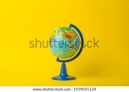 Earth globe on clean yellow background. Education, school, study and knowledge background concept.