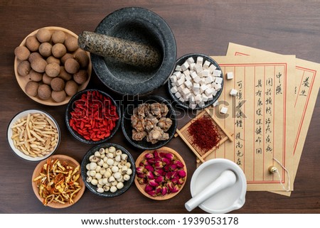 Ancient Chinese medicine books and herbs on the table.English Translation:Traditional Chinese medicine is used in the prevention and treatment of diseases, has the function of rehabilitation. Royalty-Free Stock Photo #1939053178