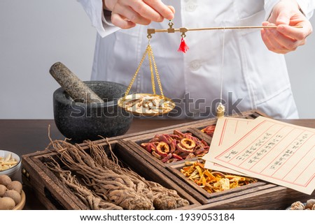 Ancient Chinese medicine books and herbs on the table.English Translation:Traditional Chinese medicine is used in the prevention and treatment of diseases, has the function of rehabilitation. Royalty-Free Stock Photo #1939053184