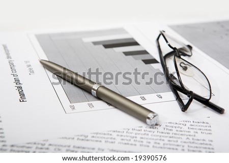 Close-up of business objects: documents, pen, glasses