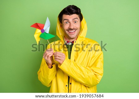 Photo of brunet impressed guy play toy wear cloak isolated on green color background