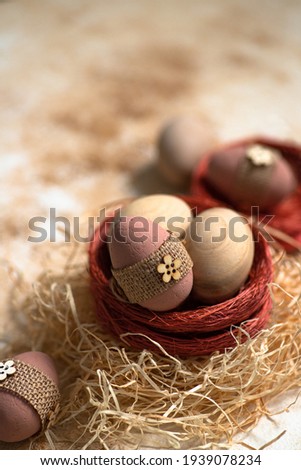 Easter eggs in a nest on a pastel marble background. Happy Easter greeting card. Rustic Easter decoration. Easter close up composition