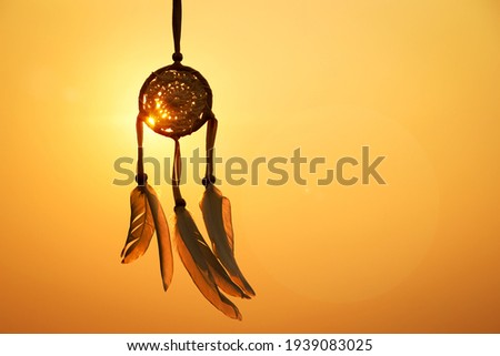Dreamcatcher with white feather thread and beaded string. Handmade Dreamcatcher.The light of the setting sun. Royalty-Free Stock Photo #1939083025