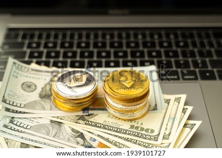 Ethereum coins on a dollars and on a laptop. Trading on the cryptocurrency exchange. Cryptocurrency Stock Market Concept. Mining or blockchain technology. Business concept.