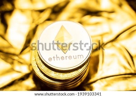 Gold ethereum coins on a golden background. Trading on the cryptocurrency exchange. Cryptocurrency Stock Market Concept. Virtual money concept. Mining or blockchain technology. Business concept.