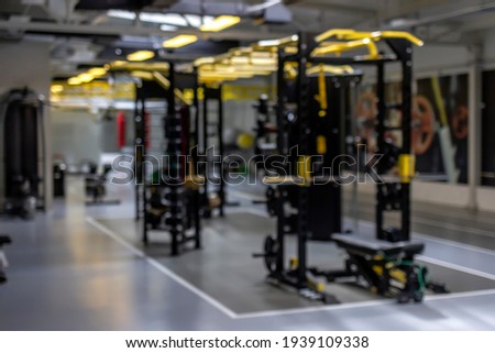 Photo of a blur gym background fitness center or health club with blurry sports exercise equipment for aerobic workout and bodybuilding. Gym background blurred. Blurred gym interior space background.