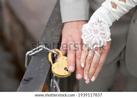 the bride's hand and the bride's that closed the heart-shaped lock. wedding custom. High quality photo