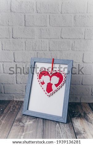 Photo frame with pink hearts  on a brick wall background.