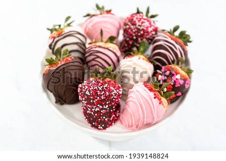 Variety of chocolate dipped strawberries on a cake stand. Royalty-Free Stock Photo #1939148824