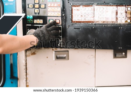 Closeup hand worker in protective safety jumpsuit uniform with black glove using tablet at factory.Metal working industry concept professional engineer manufacturing 