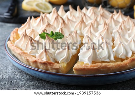 Cut delicious lemon meringue pie on grey table, closeup