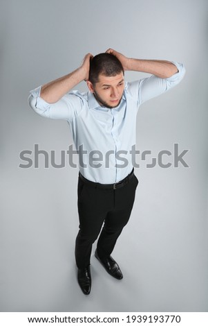 Emotional professional businessman on grey background, above view