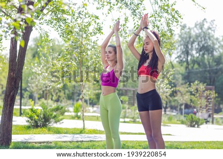 young women doing yoga outdoors