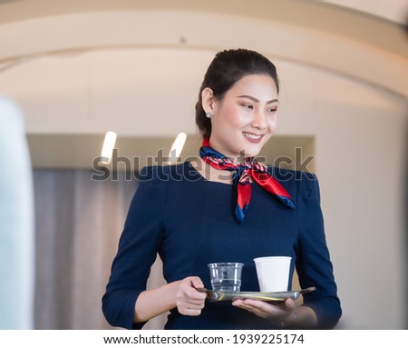 Portrait of a beautiful young smiling stewardess srevice for the passengers to board. Soft focus.
