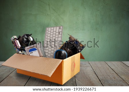 Old harddisk dive and motherboards and used keyboard with mouse old computer hardware accessories in paper boxes on wooden floor, Obsolete equipment is electronic waste Reuse and Recycle concept. Royalty-Free Stock Photo #1939226671