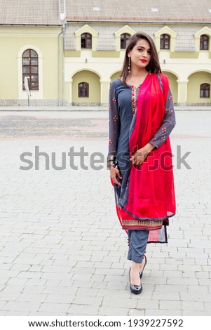 Indian girl walks on a city street. Girl in traditional Indian clothing, salwar kameez Royalty-Free Stock Photo #1939227592