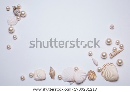 Sea shells and pearls on the white background, with free space for text.