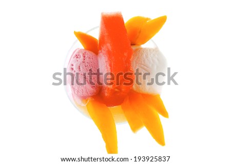 small transparent glass cup with ice cream and tropical fruits isolated on white background