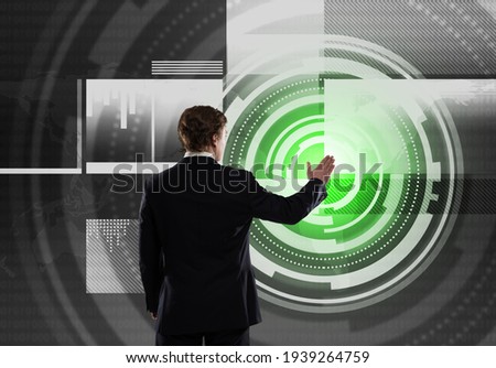 Businessman standing with back and using media virtual screen