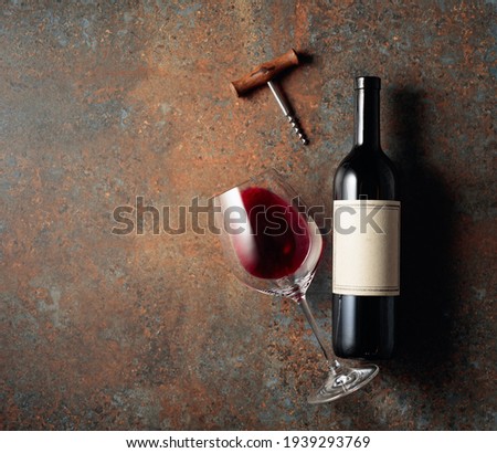 Red wine on an old rough background. Bottle with an old empty label. Top view.