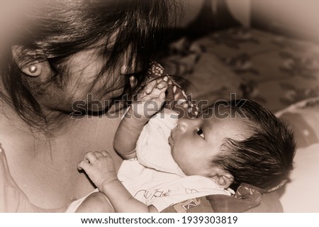 Adorable Mom and lulling newborn baby son. Loving portrait of happy mum hugging infant child on hands. Young Mother and little baby emotional attachment on Maternity Leave at home. Good morning.