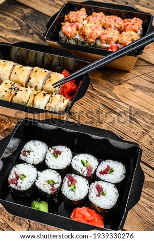 Japanese restaurant food in take away, set delivery box. Wooden background. Top view