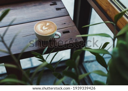 Coffee latte art on wooden bar Royalty-Free Stock Photo #1939339426