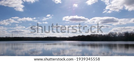 Beautiful lake with clouds and pylons in distance with copyspace